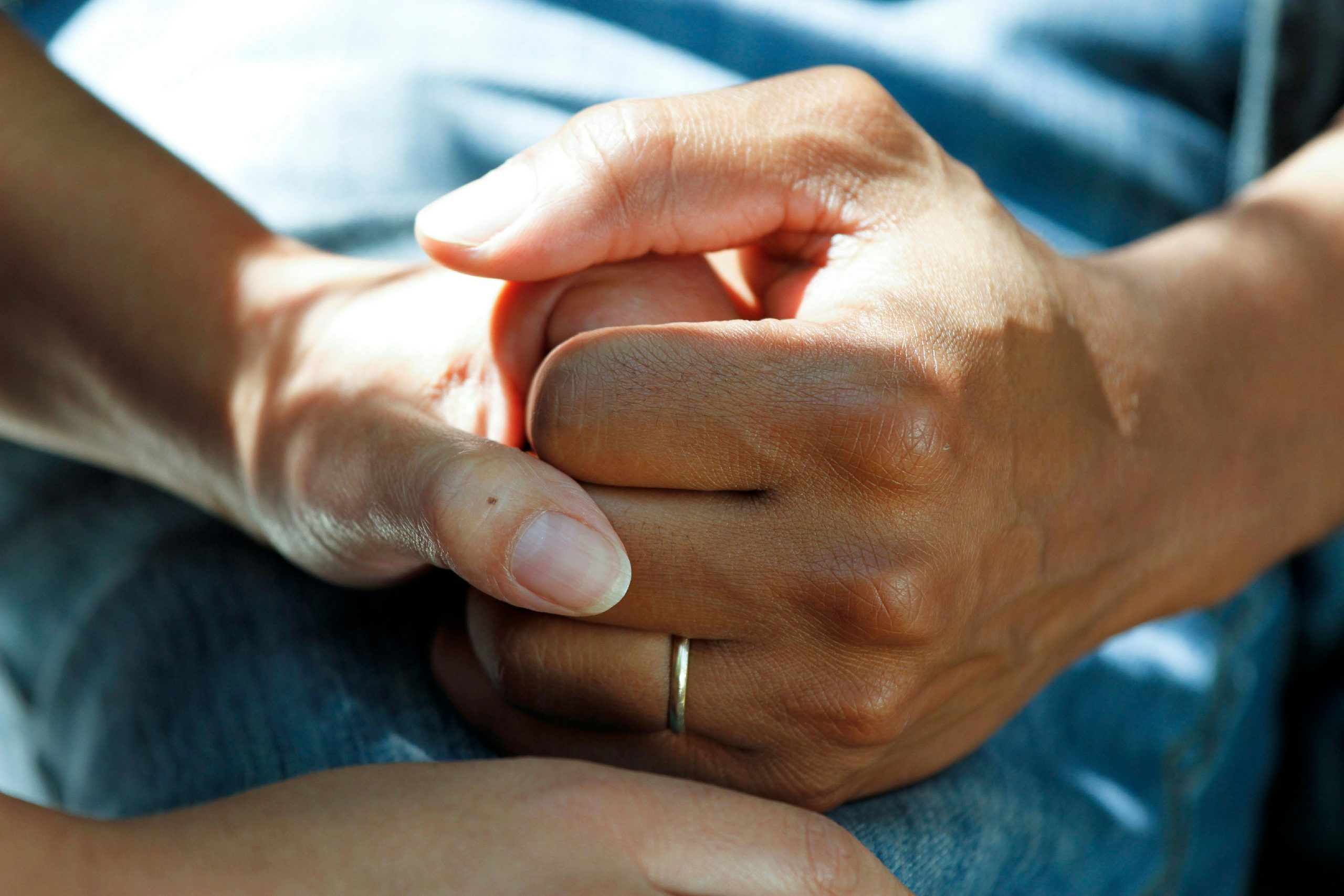 Caregiver holding the hands of an older adult during in-home senior care in Phoenix